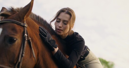 Portrait of an elegant woman on a horse. She smiles looking at the camera while lying on the animal
