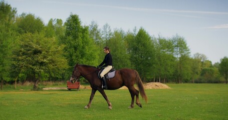 A tired woman rides a horse slowly. Picturesque countryside on a summer day