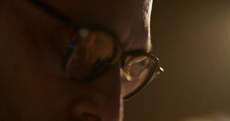 A man with glasses is intently reading. Close-up of his eyes