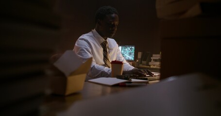 The detectives work together in the office. They use a computer to solve a crime.