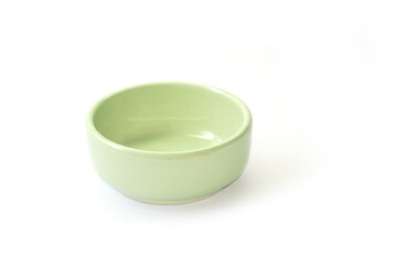 A small bowl of light green dipping sauce sits on a white background.