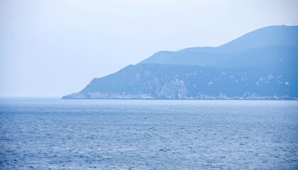 Fototapeta premium Serene Coastal Vista: A Tranquil Seascape with Distant Mountains