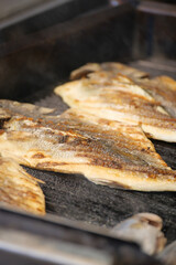 Grilled fish fillets being cooked on an outdoor grill