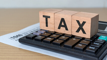 1040 U.S. tax form with calculator and TAX letter blocks. Concept of income tax filing, financial...