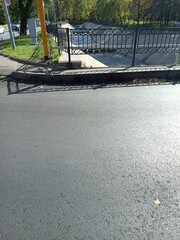 Roadway scene with asphalt and fence