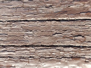 Close-up of weathered and cracked brown painted wood texture