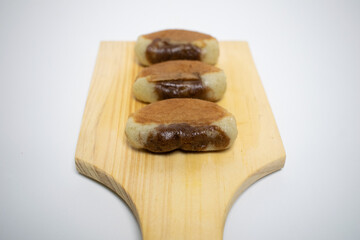 Homemade brown and white snacks on a minimalist wooden board, perfect for afternoon tea.