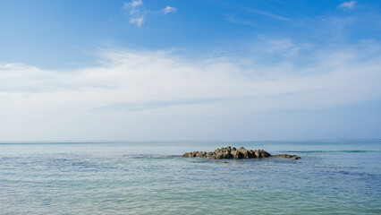 A stunning tropical island landscape with a pristine beach and turquoise water under a blue sky