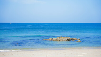 A stunning tropical island landscape with a pristine beach and turquoise water under a blue sky