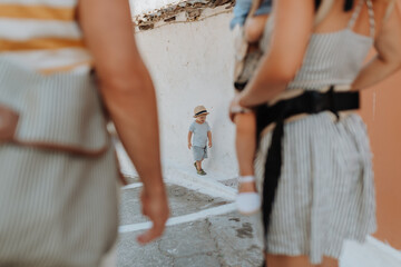 Family with two toddler children walking in town on summer holiday.