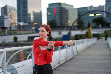 Sporty woman runner preparing for morning training, stretching.