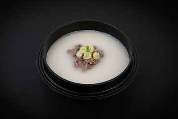 Rice porridge in a black bowl isolated on white background.