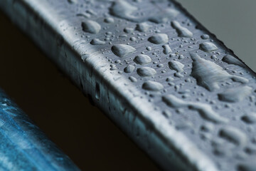 Raindrops on smooth metallic industrial object surface, weather and climate concept