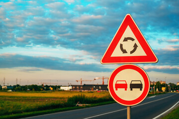 Roundabout ahead and no overtaking traffic signs by the road