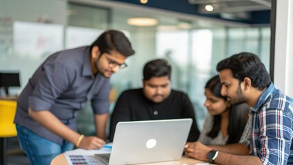 Indian startup team collaborating on digital business plan in modern office
