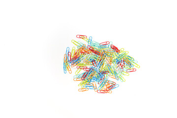 A colorful assortment of paper clips scattered across a white background,isolated in a vibrant pile