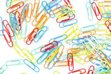 Scattered colorful paper clips isolated on a white background, creating a vibrant and playful...
