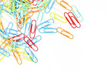 A vibrant collection of colorful paper clips scattered across a clean white surface