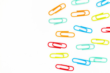 Vibrant Paper Clips Scattered on a Clean White Background, Perfect for Office Supplies Concepts