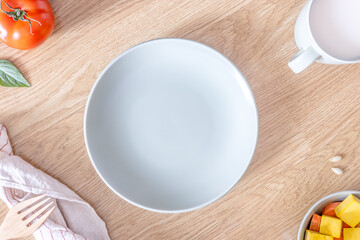 A close-up of an empty light green plate on a wooden table.