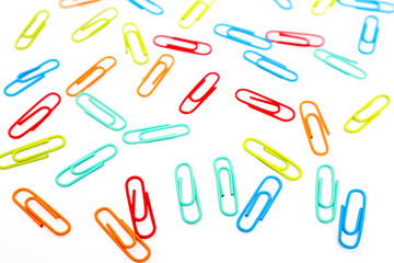 Vibrant Array of Colorful Paper Clips Scattered on a Clean White Surface Creating a Dynamic Composition