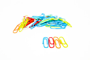 Vibrant paper clips scattered on a clean white background, perfect for office and school themed...