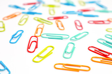 Colorful Paper Clips Scattered on a White Surface, Office Supplies Concept