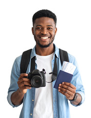 A happy traveler holds a camera and passport with tickets. A young black man looks at camera with smiling face