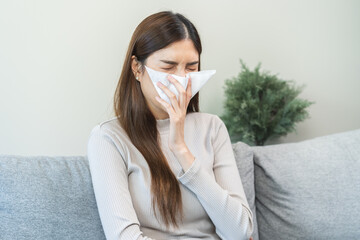 Sick, coronavirus or covid, tired asian young woman have a fever, flu and hand in use tissues paper...