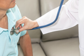 Medical professional using a stethoscope on a patient in a clinic.