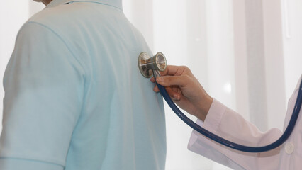 Professional healthcare provider examines patient with stethoscope.