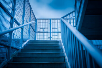 Climbing concrete stairs toward cloudy sky with metal railings outdoors. Mock up promotion information for marketing announcements and details, blank white space