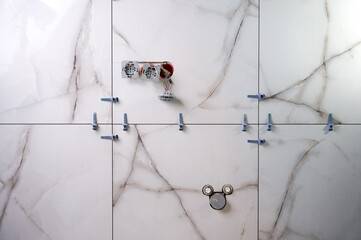 Tile leveling system. Installing ceramic tile in the new bathroom. Electric sockets in the new apartments. Shiny modern design.