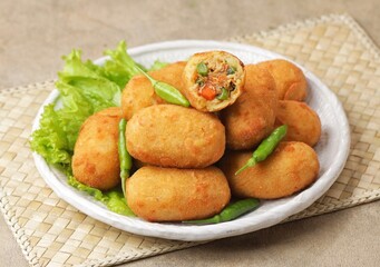 Kroket kentang. Croquettes are lumps of finely mashed potatoes filled with seasoned minced meat and...