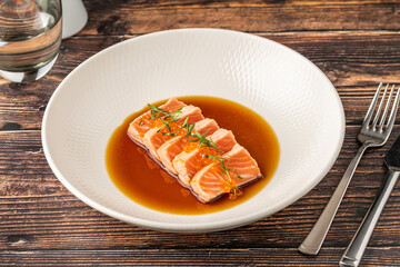 Sliced salmon tataki with soy sauce and fish roe garnish