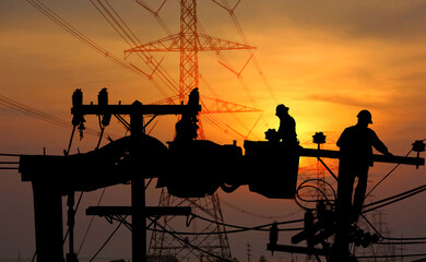 silhouette group of electric worker on crane with the high voltage electric pole  background 