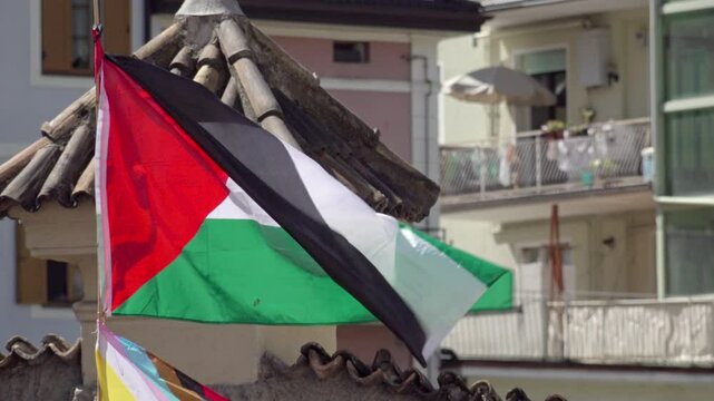 A Palestinian flag with a small hole flutters in the wind