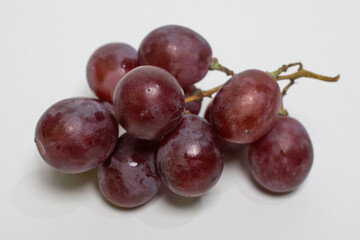 A tight cluster of sweet grapes placed on a white background.