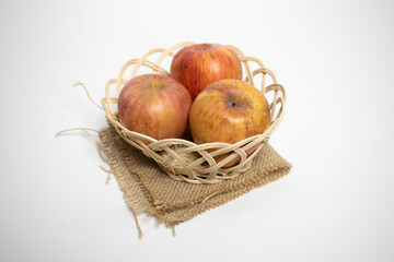 Apples, red and yellow, are arranged in small baskets.