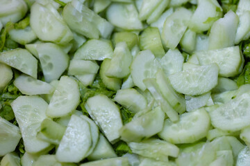 Freshly Chopped Cucumber Slices with Vibrant Green Lettuce Background