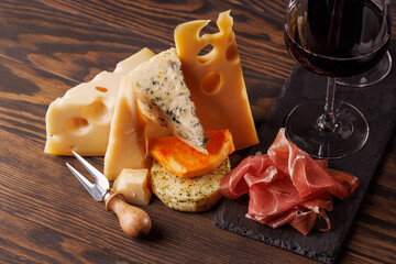 Assorted cheeses paired with glasses of wine on a rustic table