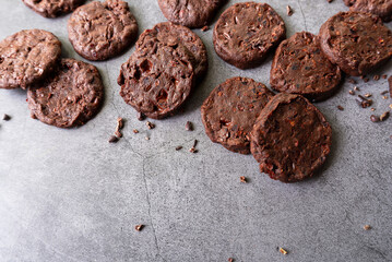 cacao nibs chocolate chunk cookies on grey background.