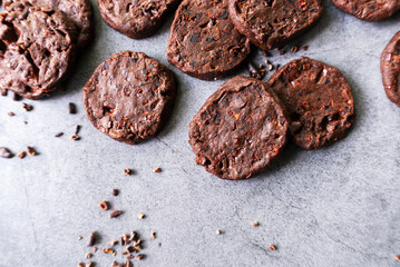 cacao nibs chocolate chunk cookies on grey background.
