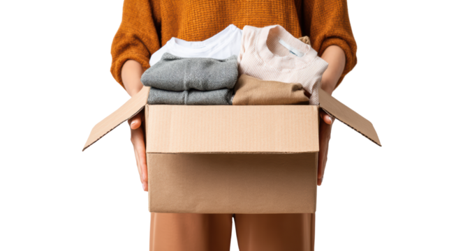 Person holding a cardboard box filled with folded clothes, showcasing casual fashion and organization.