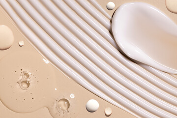 samples of cosmetic care products smear of cream gel texture on a beige background