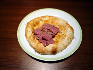 pie with slices of beef on the white plate for eating