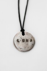 Elegant Handmade Pendant Necklace with Engraving LUNA on a White Background. Jewelry accessories.
