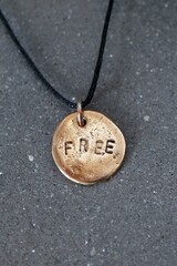 Bronze Freedom Pendant on Black Cord, Symbolizing Independence, Aspiration, and Self-Expression.