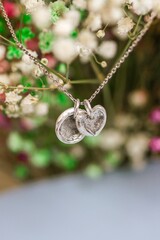 Silver Necklace with Fingerprint and Heart Charms on Delicate Floral Background, Sentimental Gift.