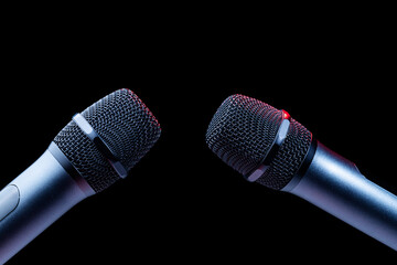 Close-up of microphone in studio or concert performance on stage, on black background.